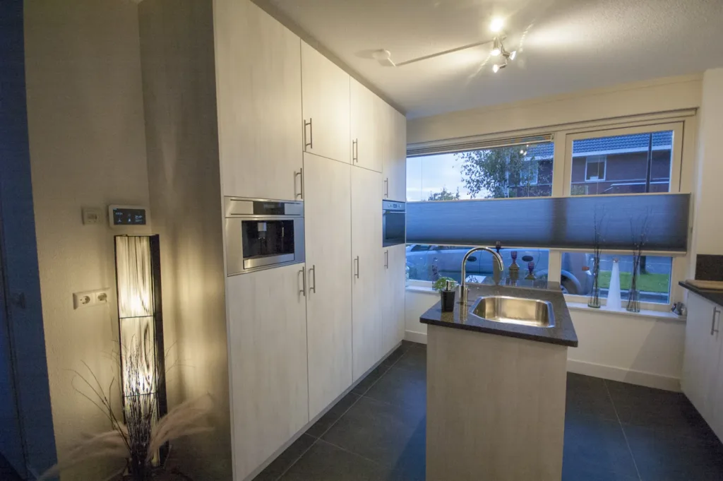 Complete keuken met kastenwanden & spoeleiland in lichtgekleurd houtmotief